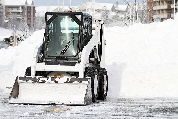 Multi purpose mini loader equipped with a snow plow. Shallow dof with focus on loader.